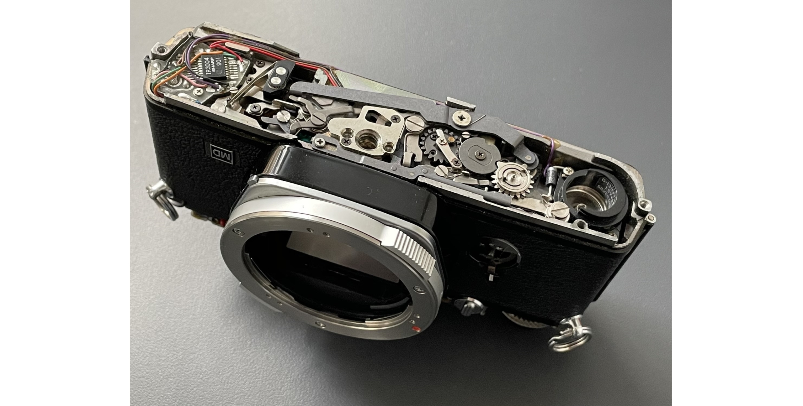 Одна з аналогових камер у частково розібраному вигляді, посилання на фото: https://www.ifixit.com/News/47088/finding-and-fixing-an-old-film-camera-part-1-the-road-to-olympus